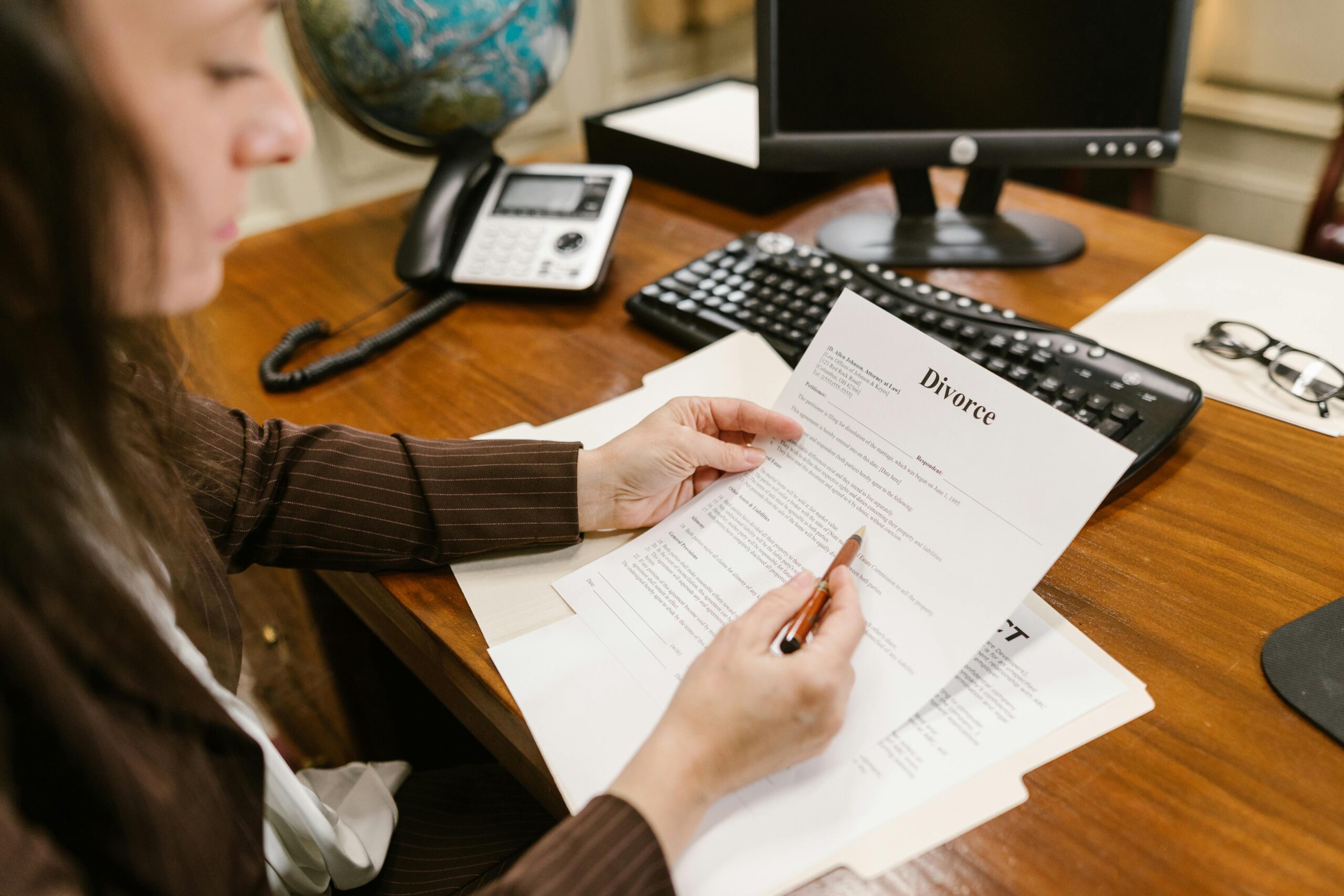 A lawyer examines divorce documents at a desk in a law office setting, emphasizing professionalism.